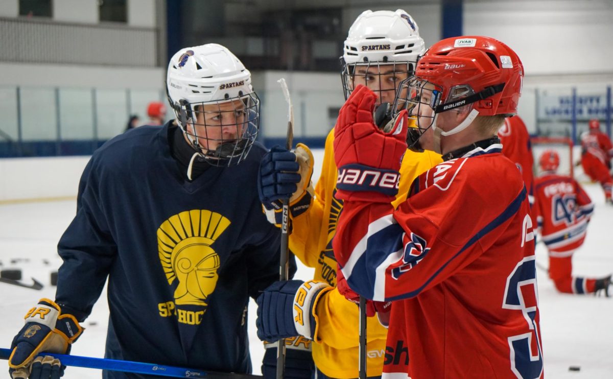 HOCKEY LANGUAGE. Spartan hockey players help explain a drill to a visiting Järfälla player.