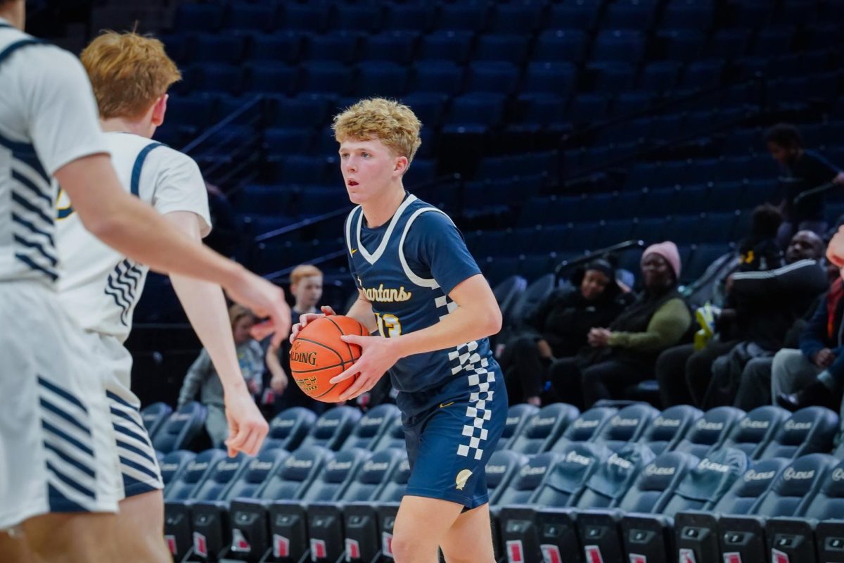 LOOK. While junior John Grimsrud has possession of the ball he looks for an open pass.