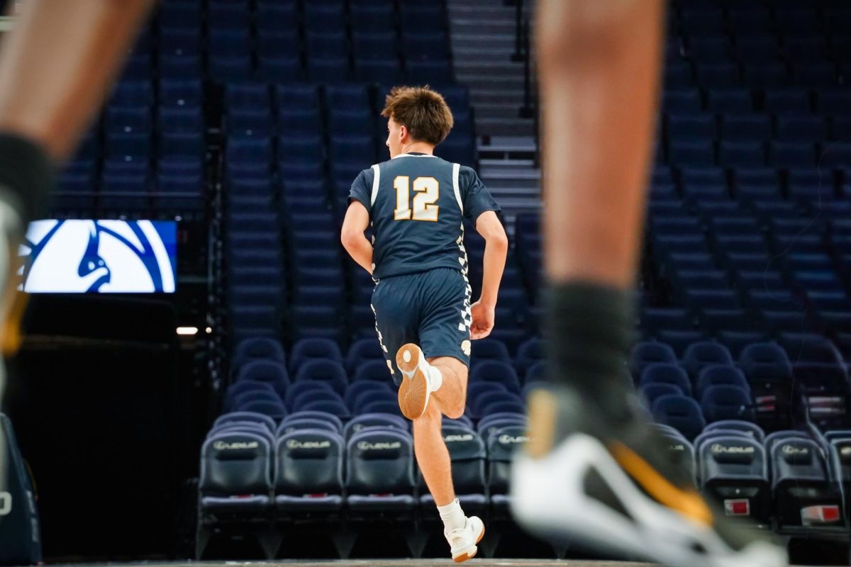 CHECK. Junior Miles Vogenthaler checks to find open players while on defense, as the ball comes down the court. 