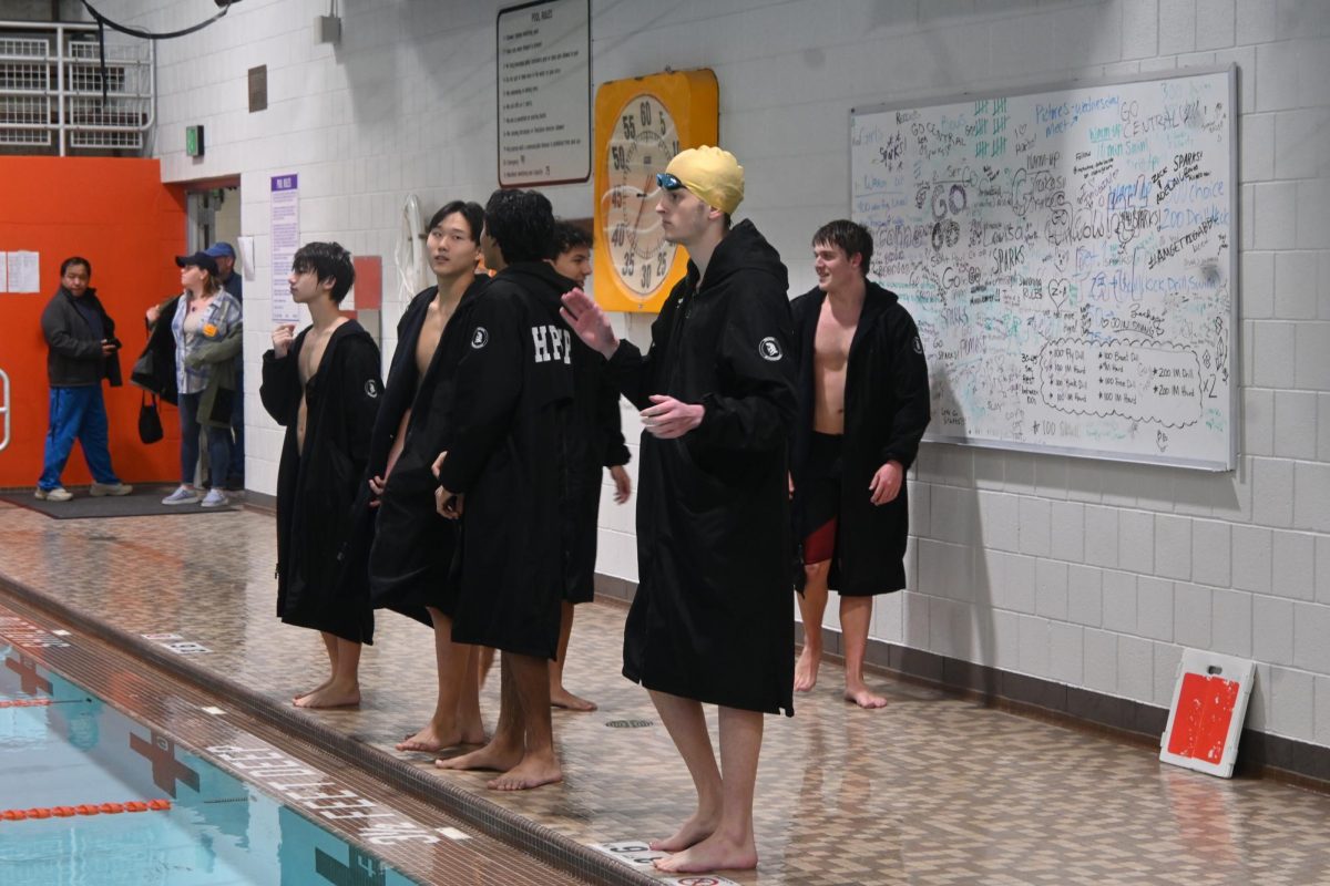 SUPPORT. Junior Alex Haupt cheers for his Trojan teammate during 200-yard freestyle relay.
