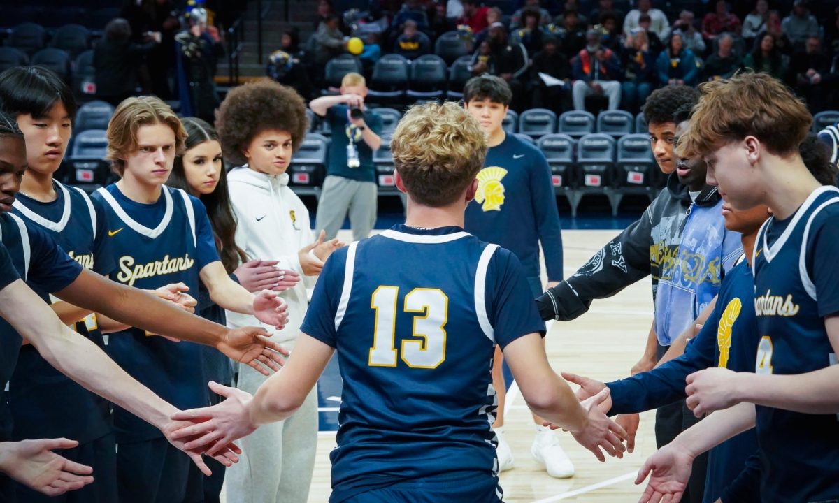 INTRO. Grimsrud hits his teammates hands while entering the court for the starting line up.