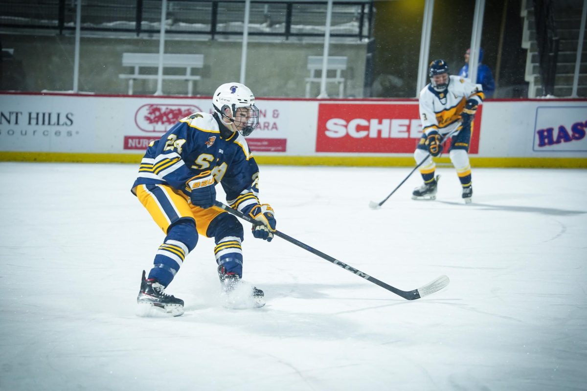 BRAKE. Henry Conlin keeps up, following the puck.