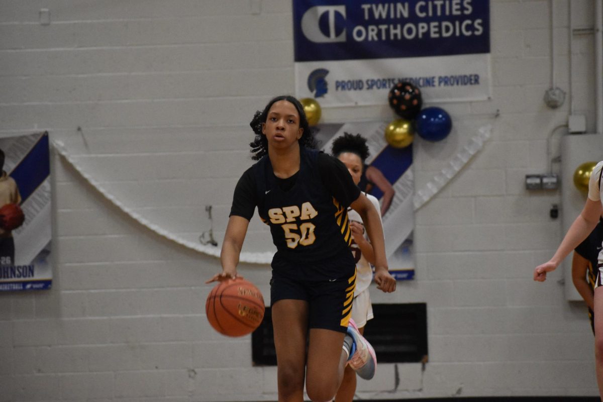 DRIBBLING. Seventh grader Jayda Brown runs down the court, dribbling the ball before landing a layup.