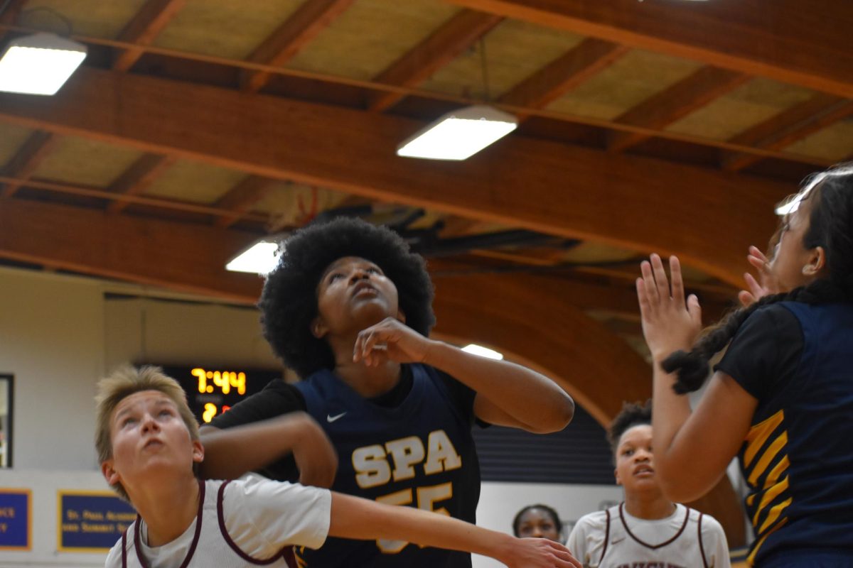 SENIOR STAR. Nijah Johnson jumps up to rebound the ball, going head to head with an opposing player.