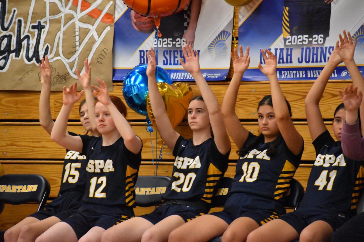 FREE THROW TRADITION. The team puts their hands up and wiggles their fingers every time a player attempts a free throw, a tradition for luck of making the shot.