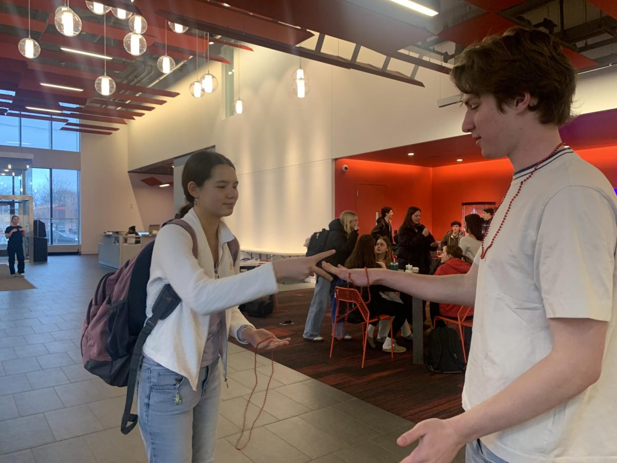 ROCK, PAPER, RIVALRY. 
Junior Iris Luther-Suhr wins against junior Miles Messier early on Wednesday morning just after recieving their beads from the SAC members at the Huss doors.