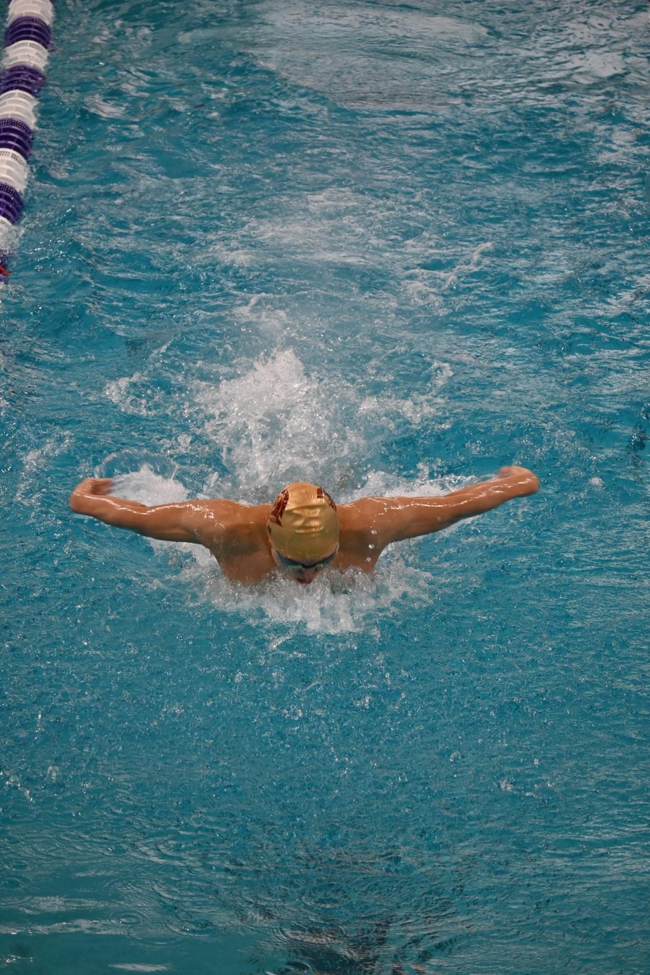 Senior Ben Lee breathe during his 100 yard butterfly race during the teams conference meet. 