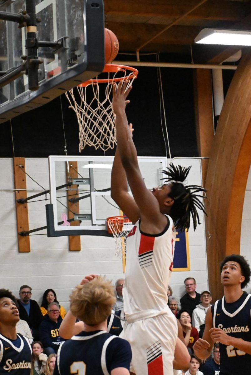 BREAK THROUGH. Camden High's #1 jumps and puts the ball in the basket after breaking through the Spartan's defense. He also proved to be a strong force in the first half of the game.  