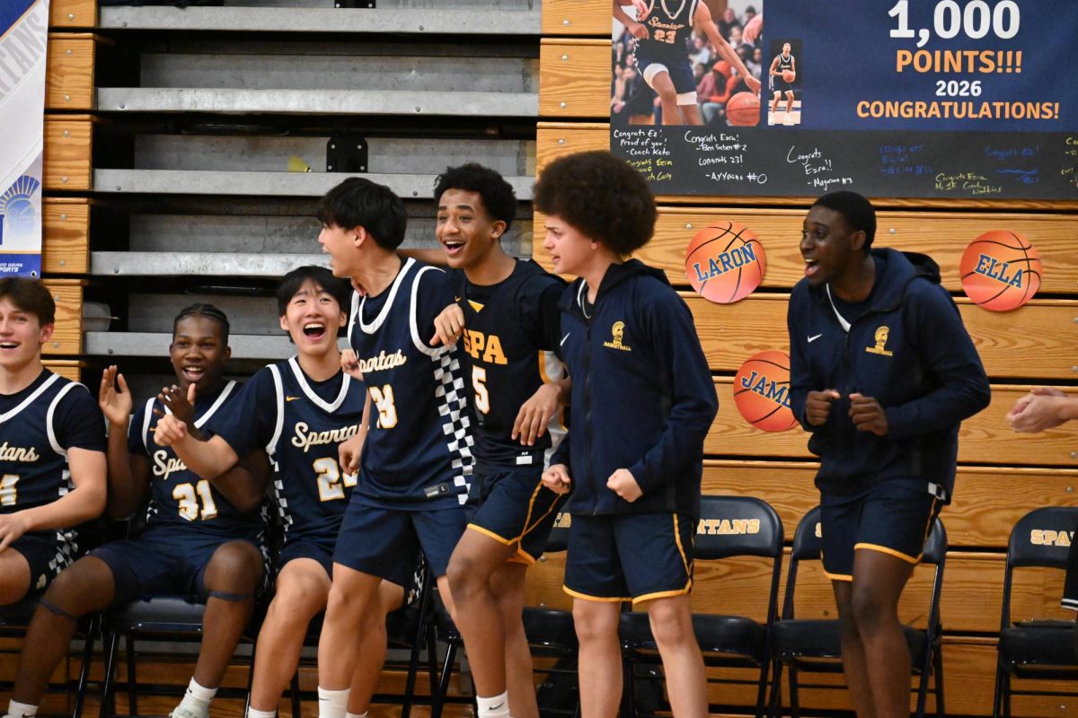 OFF THE BENCHES. After freshman Magarsaa Mullata's point, players on the bench get on their feet and cheer.