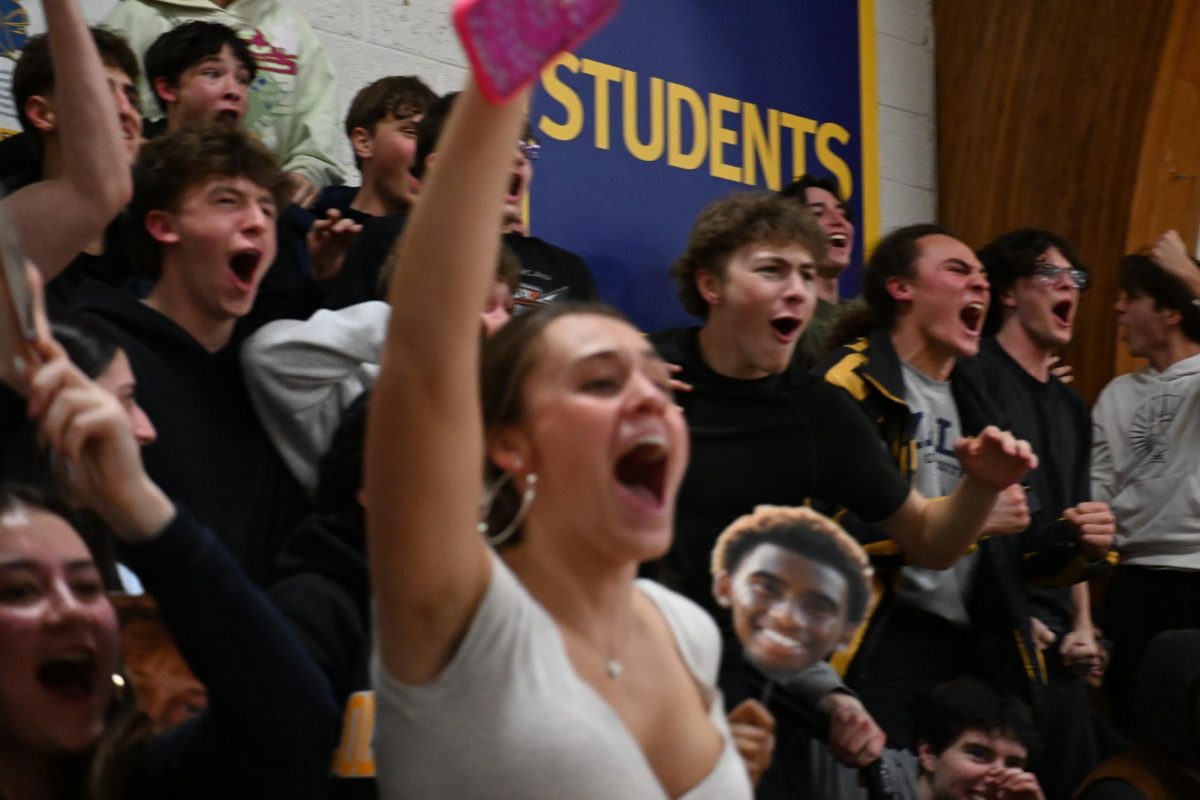 STUDENT SECTION HYPE. Student fans jump to their feet to cheer on the seniors after Mullataa's and Cunninghams point.
