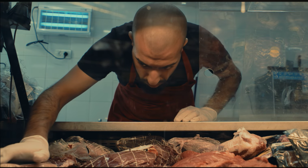 CLEAVER FEAVER. The main character, Samir, works as a butcher at a supermarket in Tel Aviv, and this is a film of quiet observation and reveals a strange beauty in the practiced choreography of daily work. (Screen capture from Butcher's Stain official trailer)