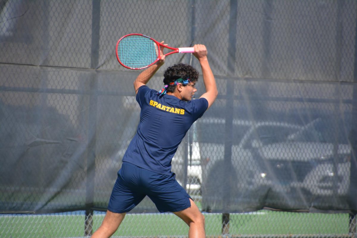 PRECISION UNDER PRESSURE. Holding his ground at No. 2 singles, sophomore Lucas Laguna carves a backhand slice during a match against Edina. Laguna, a standout for the Spartans, utilized his defensive range and tactical precision to keep pace with a formidable rival team.