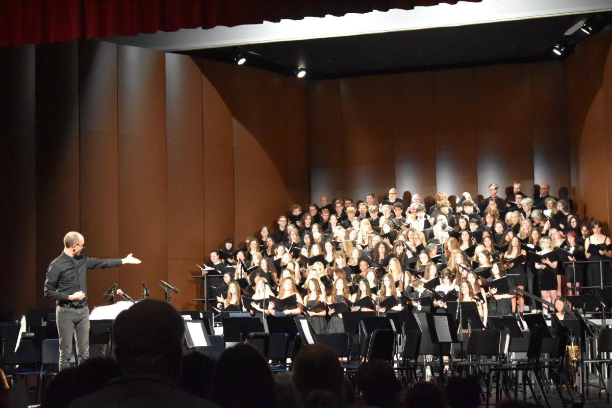 APPLAUSE. Choir director Tim Kraack acknowledges the ensemble after finishing the choir section of the concert.