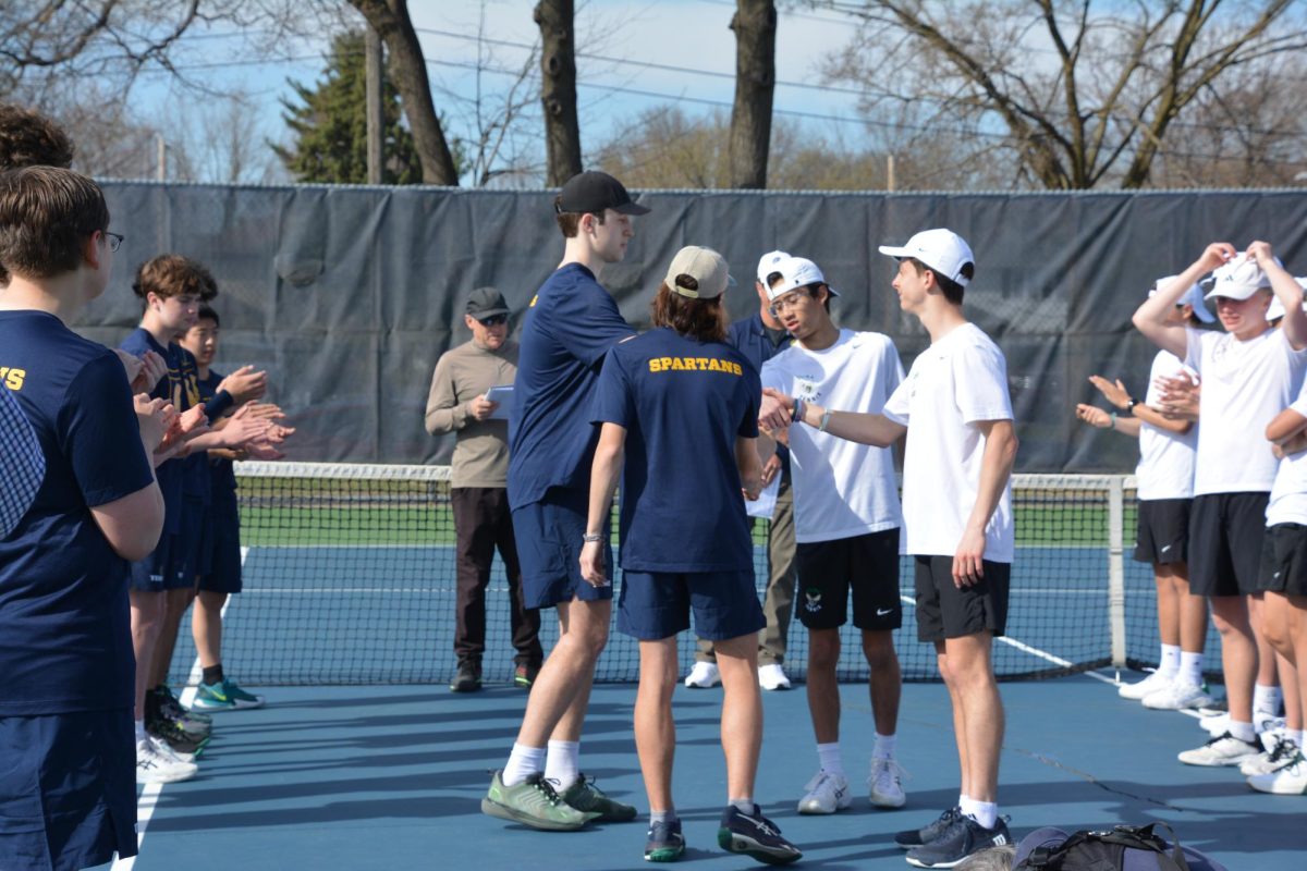 STARTING LINEUP. Junior Gavin Leuthold and sophomore Caleb Colton shake hands with their opponents prior to their match. The pair represented the Spartans in a key doubles contest during the meet against Edina.