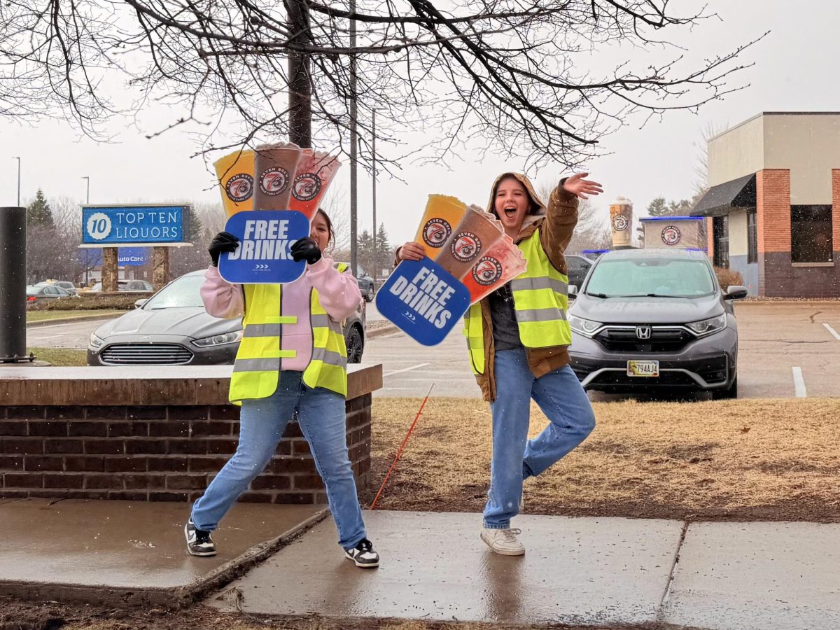 SMILES. Workers from 7 Brew walk up and down the street in neon vests, holding signs and waving at the line of cars while free drinks were passed out.