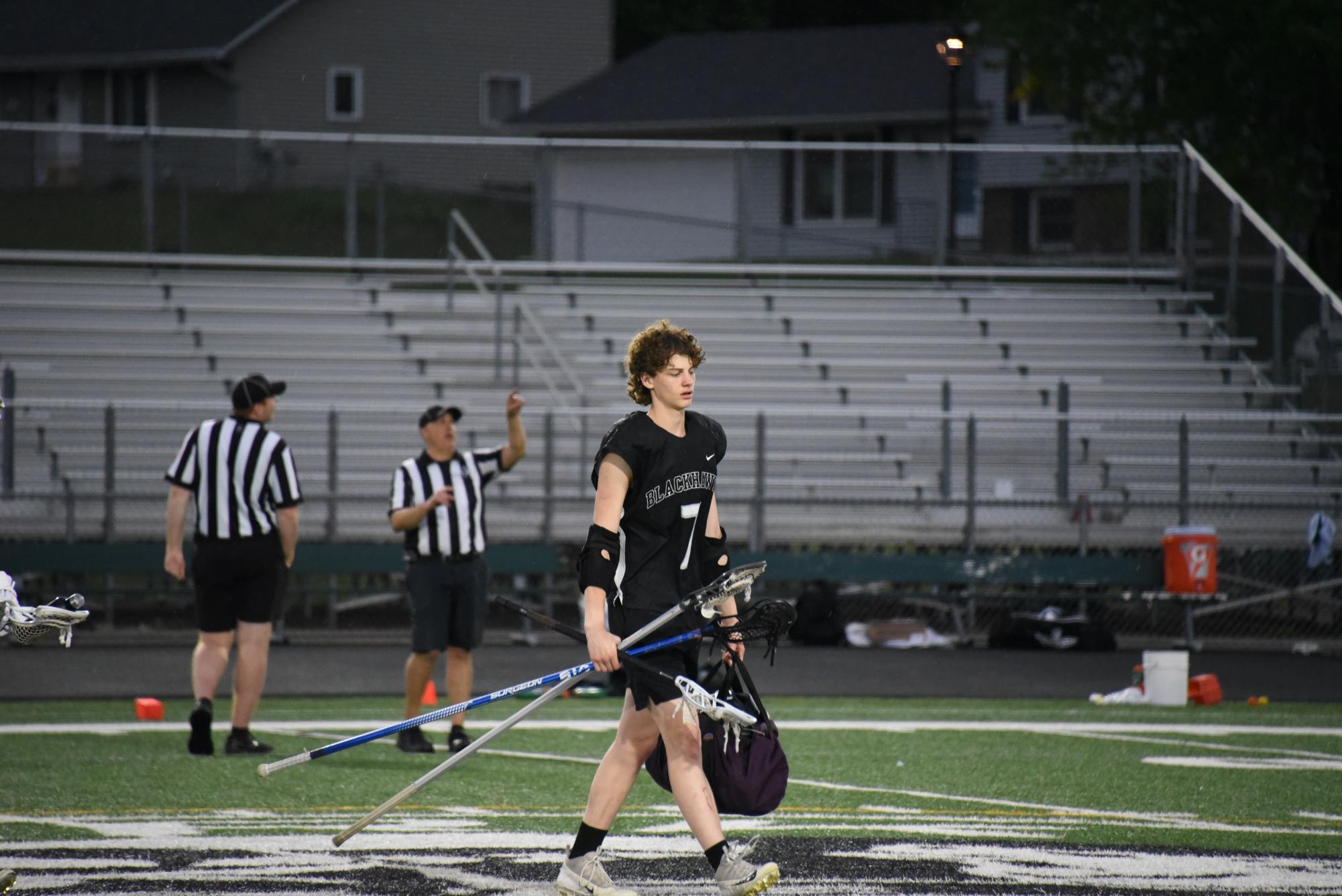 SEEK SHELTER. Junior Lachlan Gaspard gathers his equipment halfway through the game as thunder and lighting strike nearby. The game undergoes a 30 minute break to wait out the lighting for safety concerns.