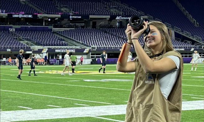 CAPTURING THE SPIRIT. Community Engagement Manager Audrey Peltier takes photos at the MSHSL Boys Soccer playoffs at U.S. Bank Stadium in November of 2024. She hopes to major in sports media or journalism in college