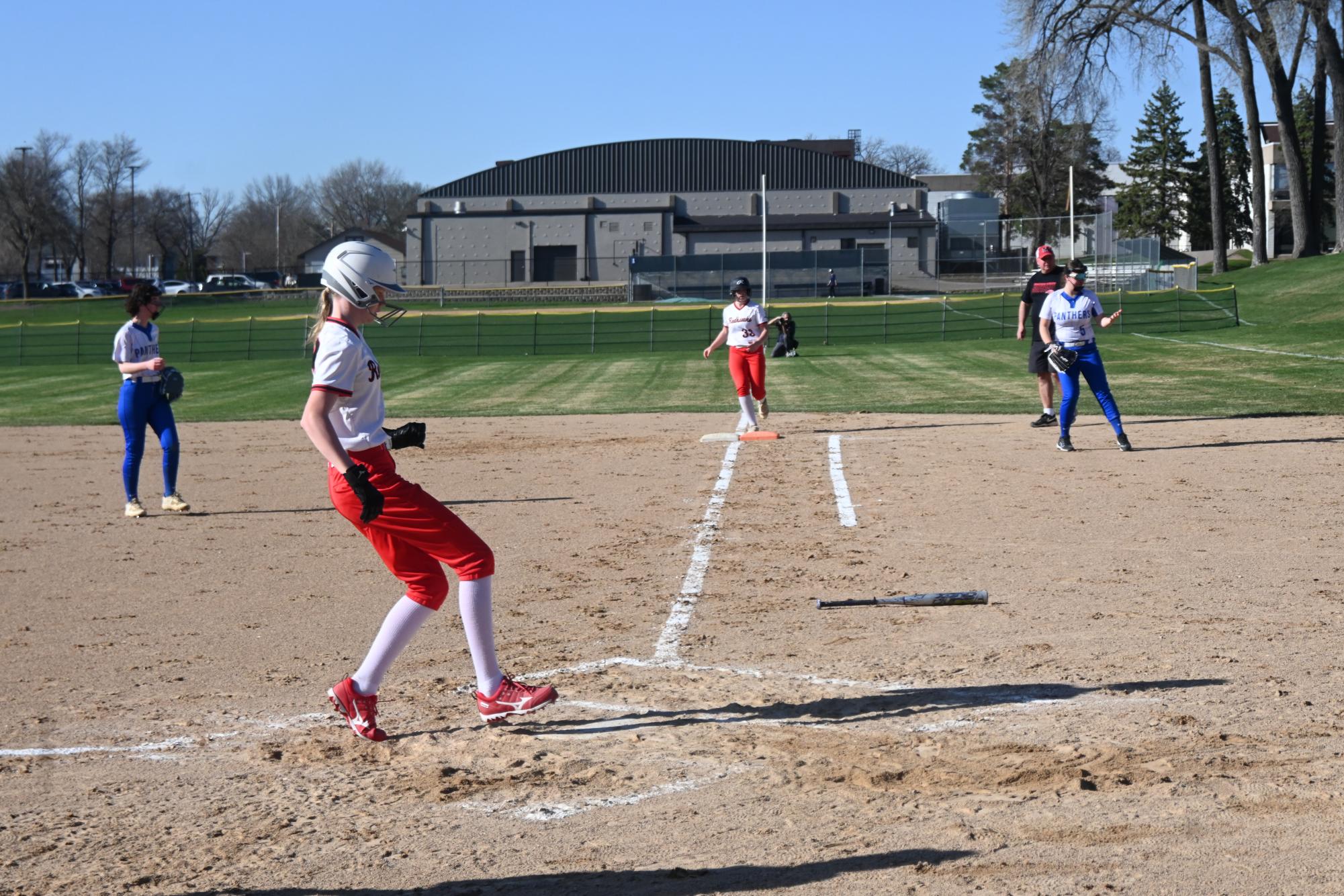 HITTING HOME. Eighth grader Alida Nestingen runs through home plate, putting a run on the board for the Red Hawk Co-op team. 